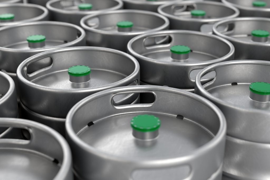 Refurbished stainless-steel beer kegs stacked in rows ready for rental delivery across Europe